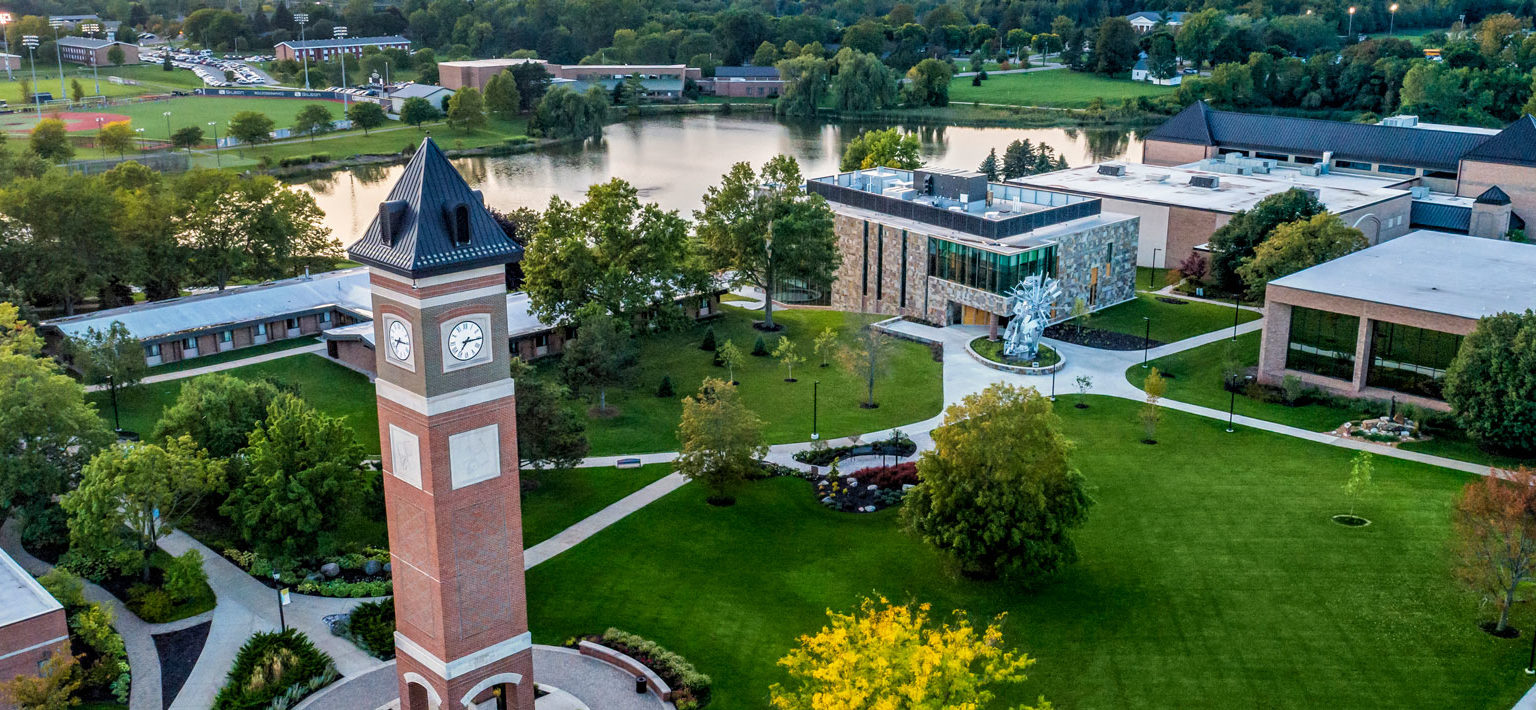 Aerial view of the Cornerstone University campus that shows academic buildings, bell tower and pond