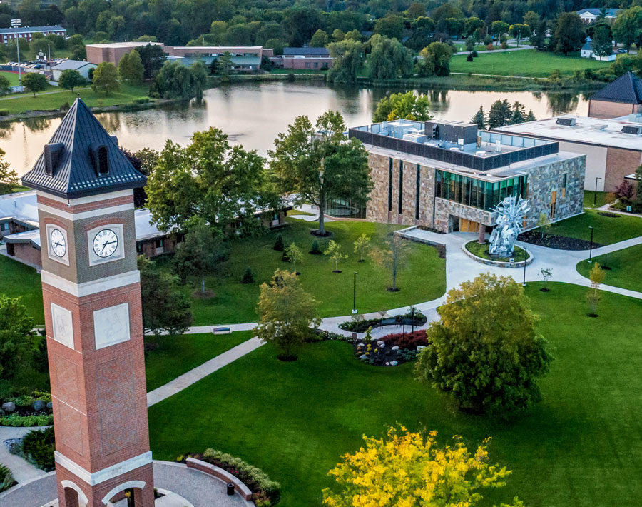 Aerial view of the Cornerstone University campus that shows academic buildings, bell tower and pond