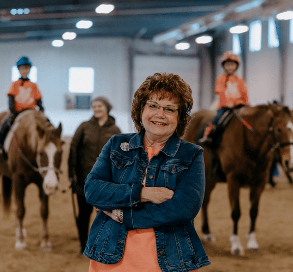 Female graduate student implementing her education by leading a reading and riding program for students