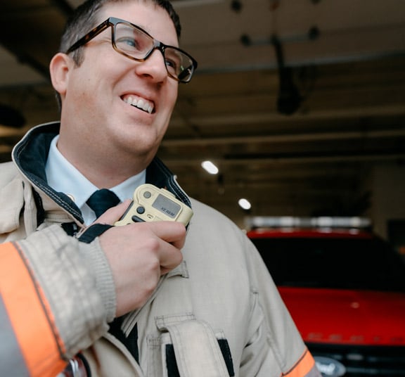 Male doctor of education graduate from Cornerstone University wearing his fire department uniform at his workplace