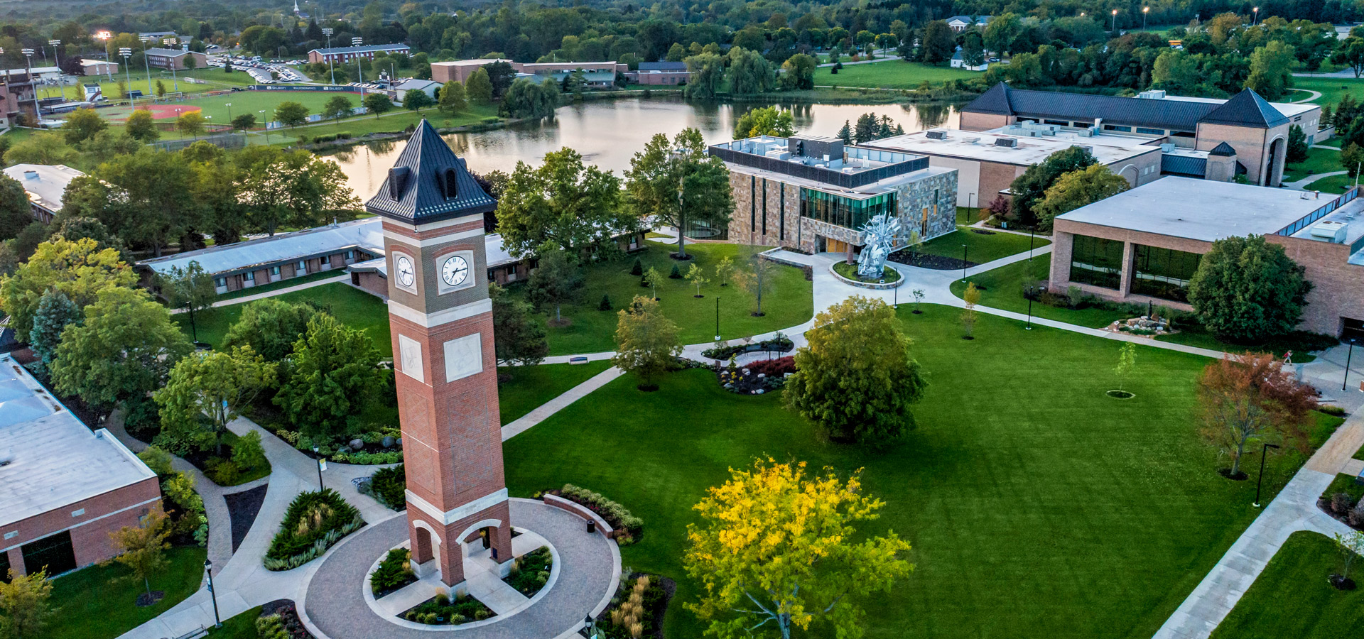Aerial view of the Cornerstone University campus that shows academic buildings, bell tower and pond