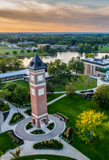 Aerial view of the Cornerstone University campus that shows academic buildings, bell tower and pond