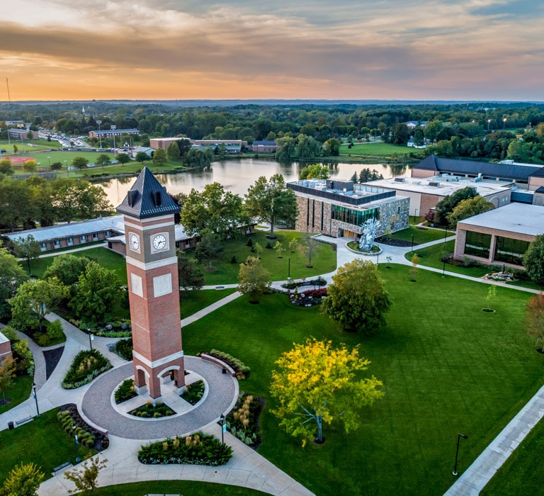 Aerial view of the Cornerstone University campus that shows academic buildings, bell tower and pond