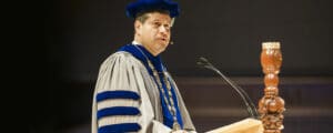 Gerson Moreno-Riaño speaking from a wooden podium on the stage of Christ Chapel at Cornerstone University