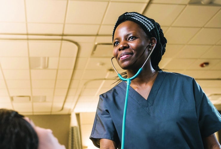 Female nursing student using a stethoscope on a mannequin