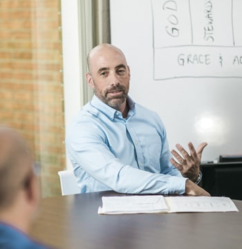 Male sitting at conference table in front of whiteboard
