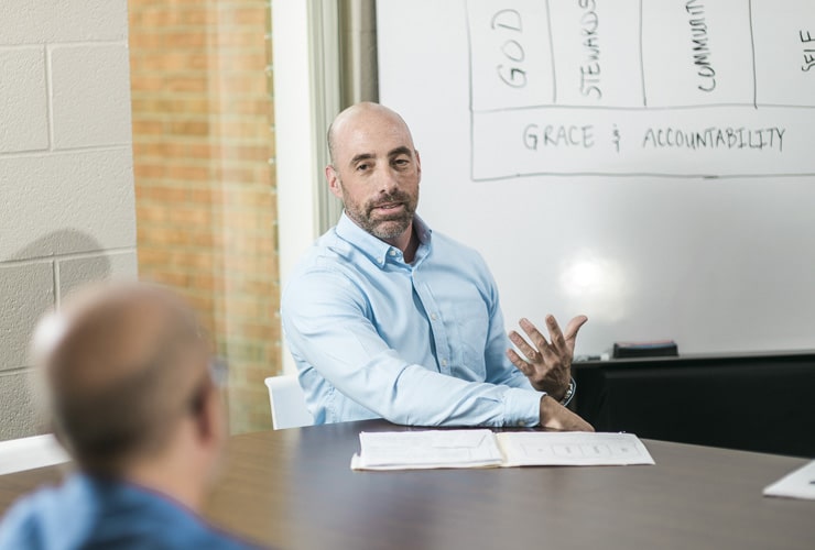 Male sitting at conference table in front of whiteboard