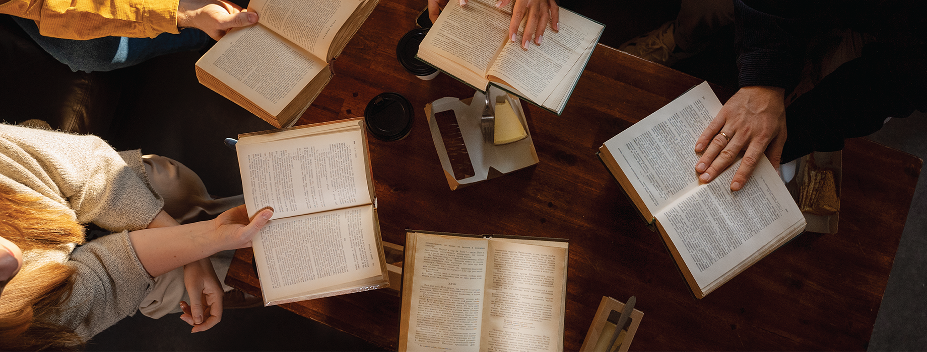 Aerial view of open Bibles in circle around a wooden table