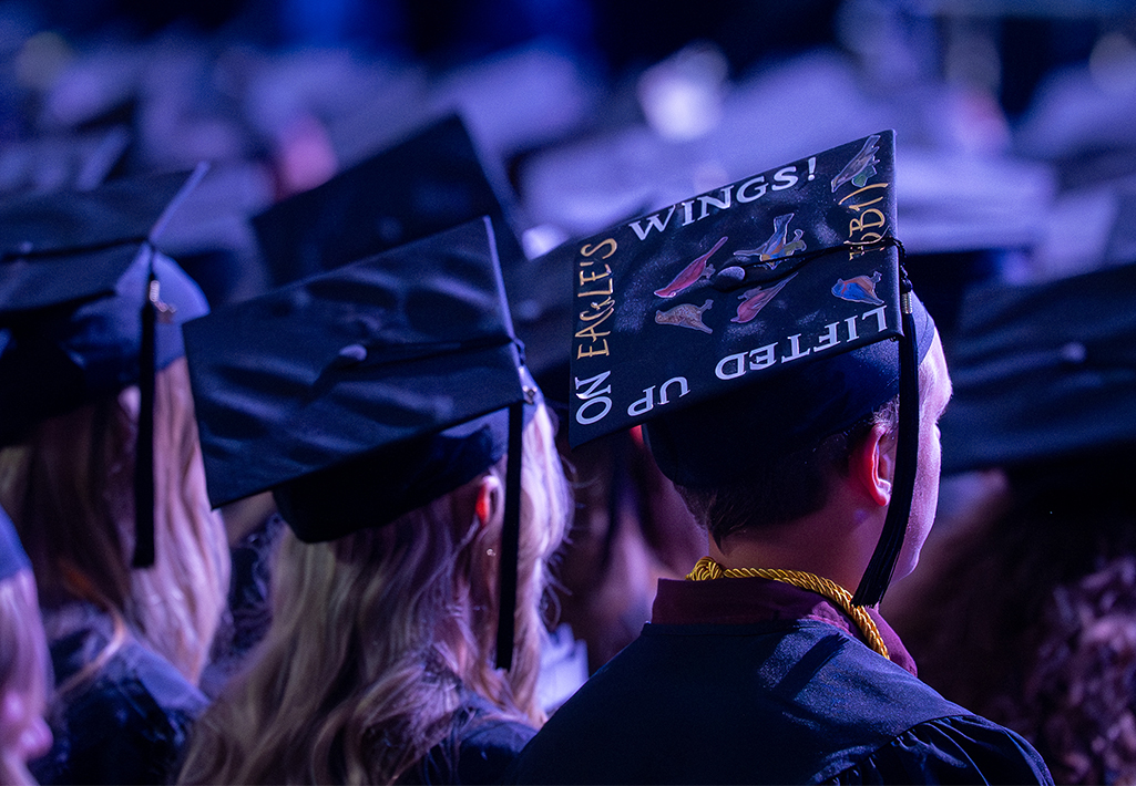 Graduates stand with mortarboards turned toward the camera, one reading Lifted Up on Eagle's Wings!, during Cornerstone University's 84th Commencement on Saturday, May 9, 2026